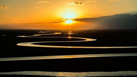 A sunset over a spiralling waterway 